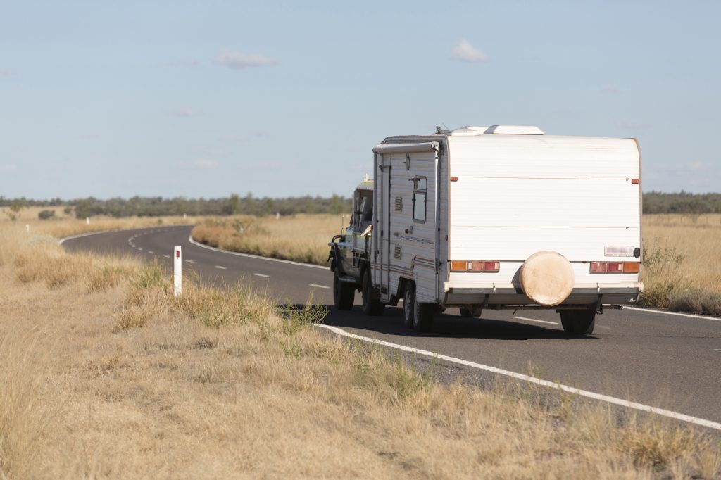 Caravan on a long rural road with dry grass either side, travelling north to Normanton